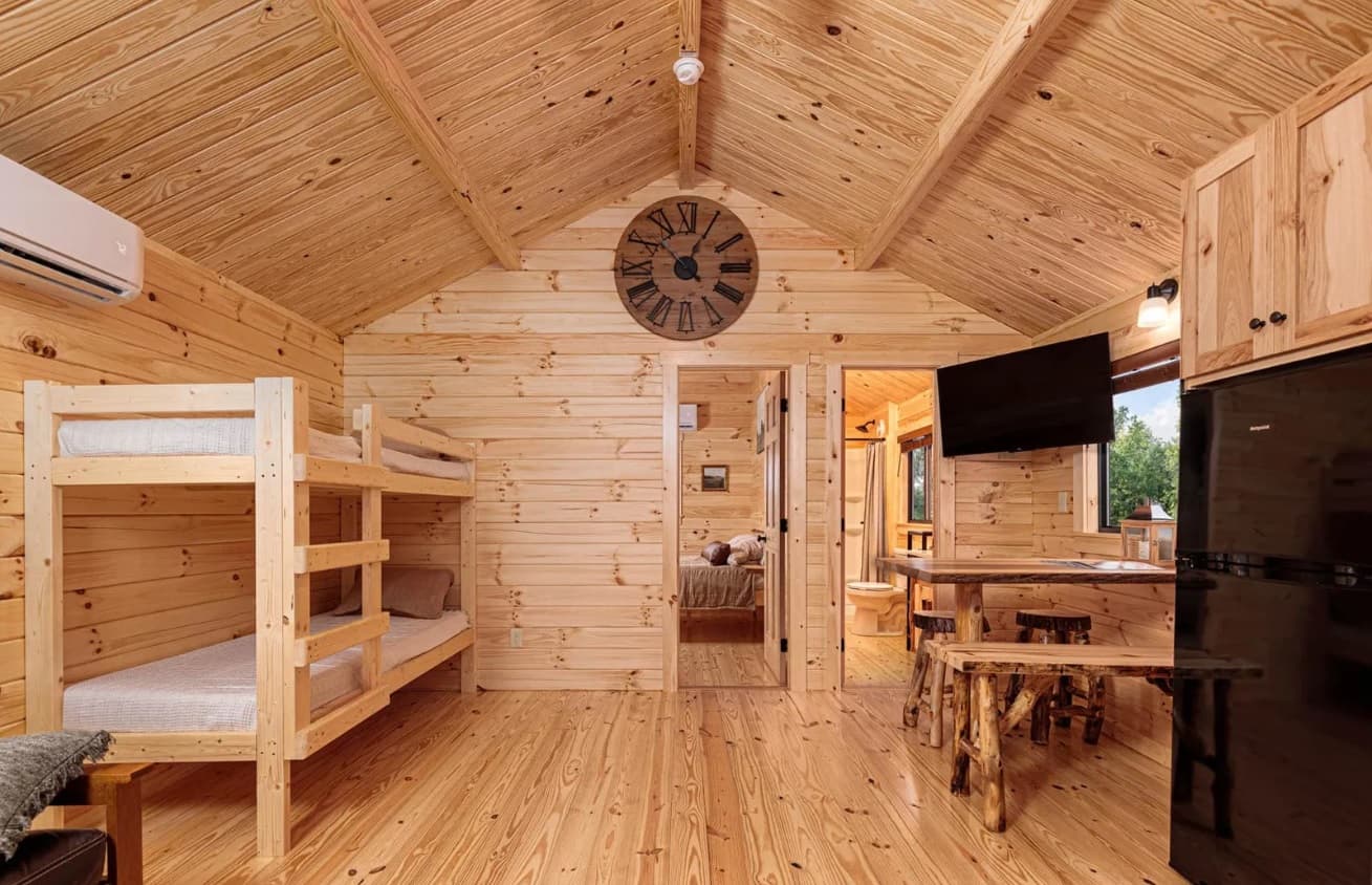 Rustic cabin bedroom with loft bunk beds and vaulted ceiling