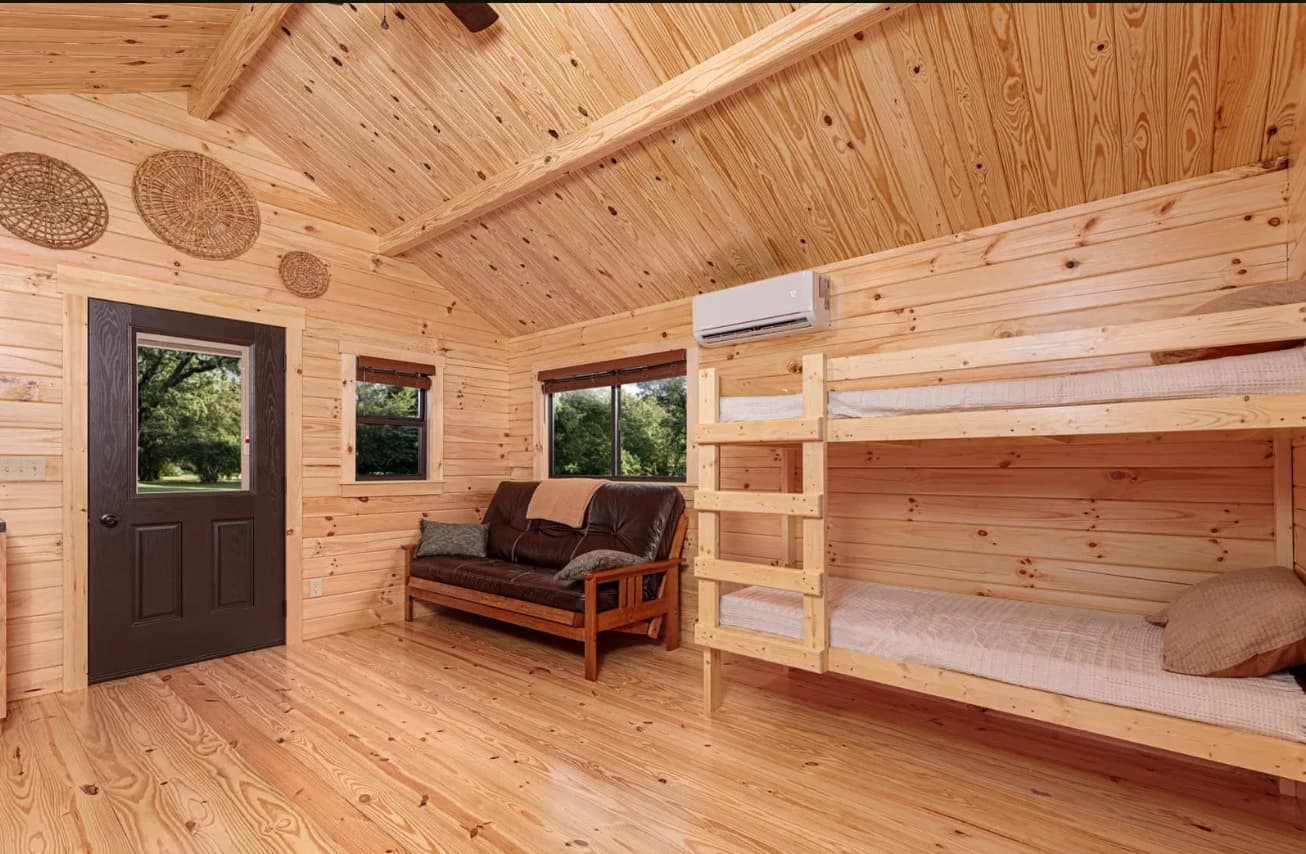 Rustic log cabin living room with bunk beds and futon