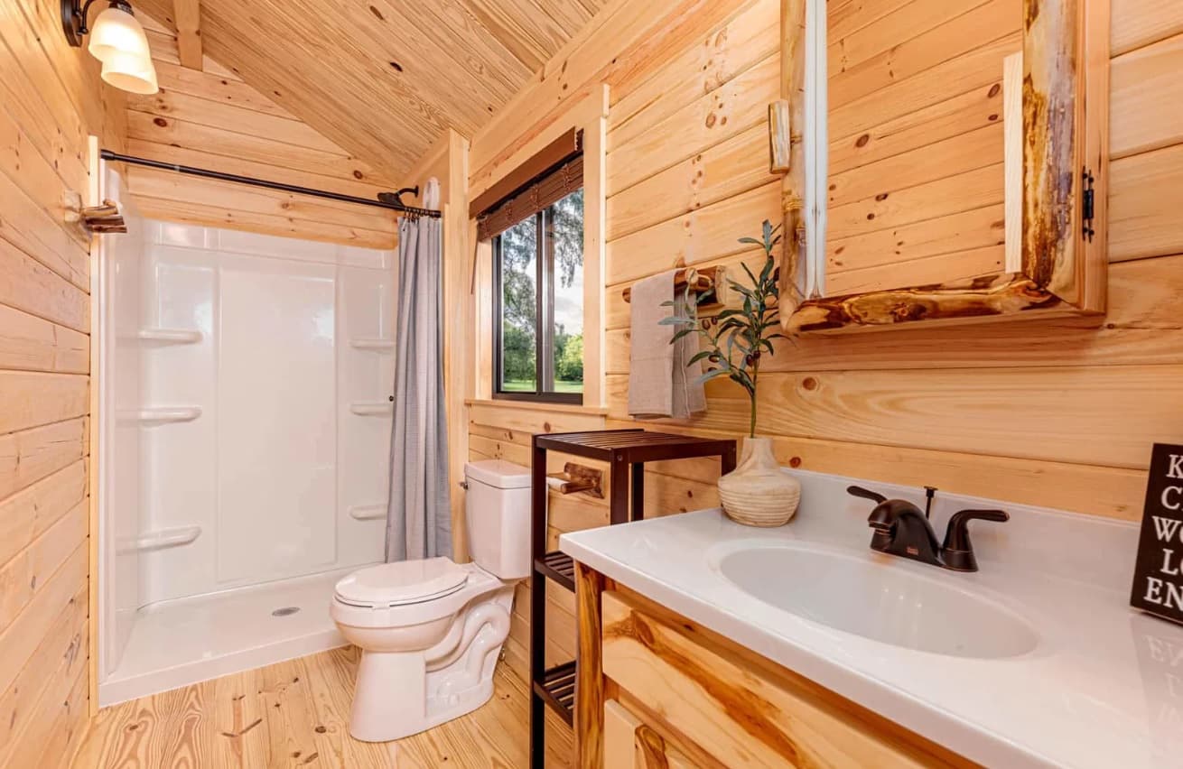 Modern log cabin bathroom with white fixtures and wood accents
