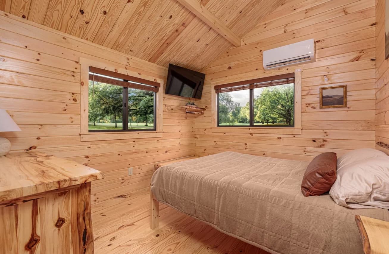 Log cabin bedroom with TV entertainment and dual windows